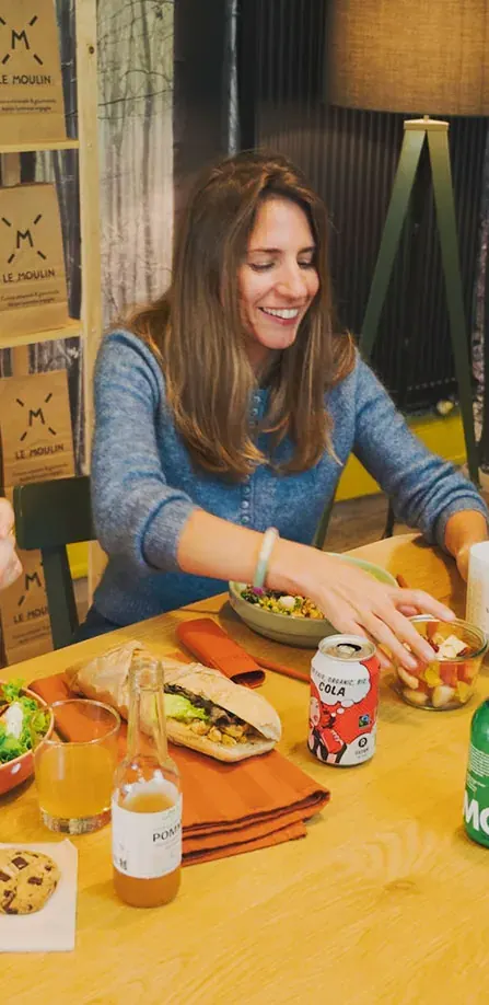 Une collaboratrice déjeune à la Cantine du Moulin, sandwich et salade sur la table