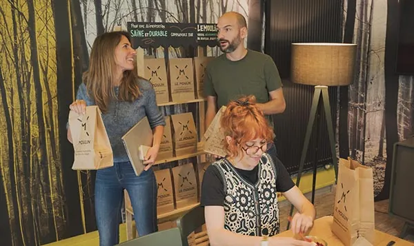 Trois collaborateurs récupèrent leurs sacs Le Moulin dans leur bureau