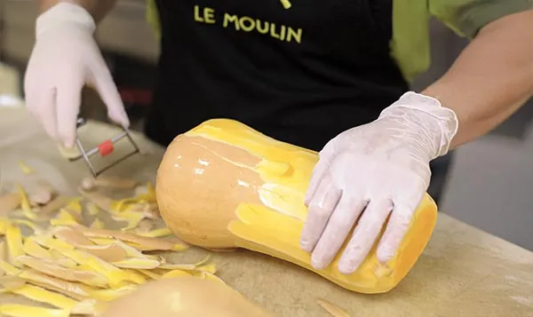 Un cuisinier du Moulin épluche une courge butternut